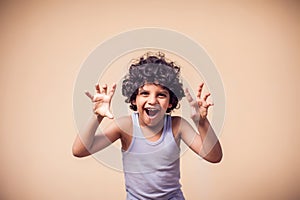 A portrait of funny kid boy showing frighten gesture. Children and emotions concept