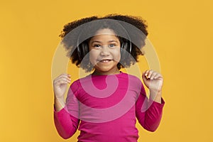 Portrait Of Funny Little Black Girl Listening Music In Wireless Headphones