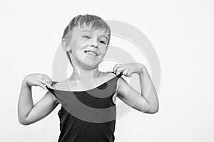 Portrait of funny little boy over white background. Happy child smiling and looking aside. Copy space. Child in a black tank top.