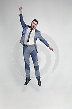 Portrait of a funny and little crazy businessman man jumping and cheering loud  on a white background