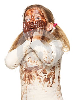 Portrait of a funny little girl with dirty face covered in chocolate