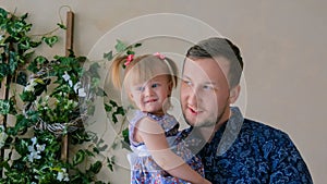 Portrait of funny little girl and her father at home