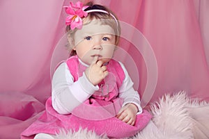 Portrait of funny lovely little girl, finger in mouth