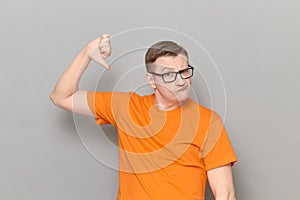 Portrait of funny man giving thumb down sign of disapproval