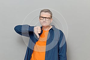 Portrait of funny man giving thumb down sign of disapproval