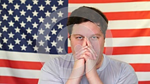 Portrait of funny man pointing away a hand gun against american flag background