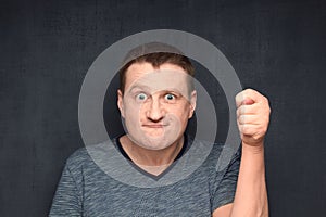 Portrait of funny man showing fico at camera