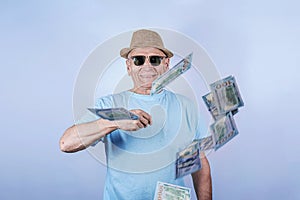 Portrait of funny old man millionaire in sunglasses waste money throw banknotes