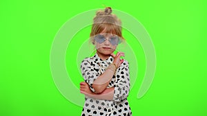 Portrait of funny playful blonde child girl in white black shirt wearing sunglasses, charming smile