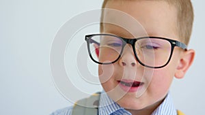 portrait of funny serious baby child boy in glasses making face grimacing camera