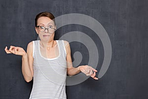 Portrait of funny shocked perplexed young woman with skewed glasses