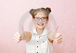 Portrait of funny smiling little girl child wearing glasses with two fingers up isolated