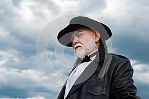 Portrait of funny stylish hipster grandfather in leather coat. Mature fashion senior man with grey beard.