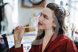 Portrait of funny woman with pencil, having fun at work.