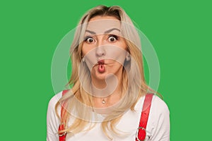 Portrait of funny wondered adult blond woman looking at camera with idiotic silly expression, making fish face