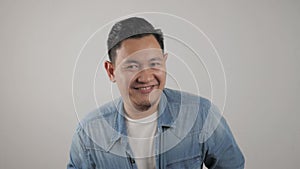 Portrait of funny young attractive cute Asian man smiling shy happily