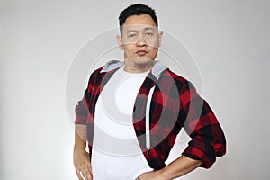 Portrait of funny young cocky Asian man shows his over confidence, hands on hips with arrogant gesture photo