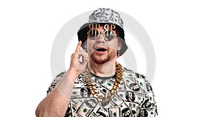 Portrait of funny young man in clothes and accessories with dollars symbols, showing index finger up