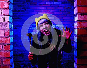 Portrait of funny zombie girl in halloween time with hammer