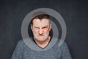 Portrait of furious man looking with hate and rage at camera