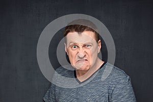 Portrait of furious man looking with rage at camera