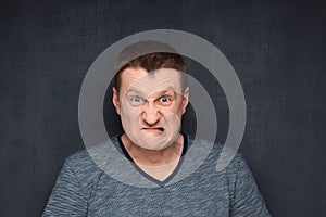 Portrait of furious man looking with rage and hate at camera