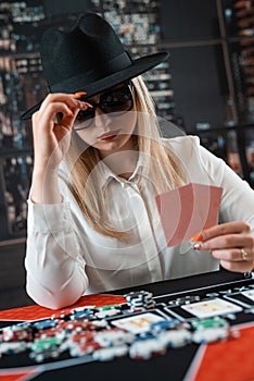 Portrait of gambling lucky woman playing poker at casino table