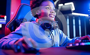 Portrait Gamer African American beautiful woman play online games computer, streamer neon room