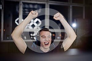 Portrait gamer guy screaming and rejoicing while playing video games on computer