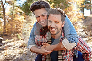 Portrait Of Gay Male Couple Walking Through Fall Woodland