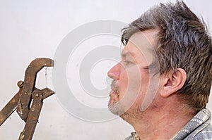 Portrait of a geezer talking with a dusty pipe wrench