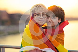 Portrait of a gender fluid couple wearing rainbow flag