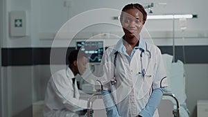 Portrait of general practitioner standing in hospital ward