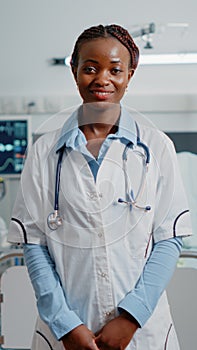 Portrait of general practitioner standing in hospital ward