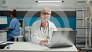 Portrait of general practitioner using laptop at health care checkup