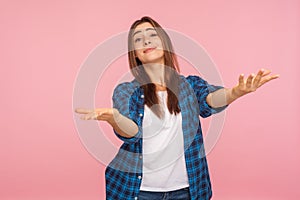 Portrait of generous kind-hearted girl in checkered shirt raising arms in gesture take everything for free