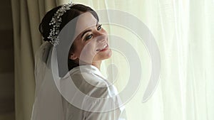 Portrait of gentle bride in a negligee near window