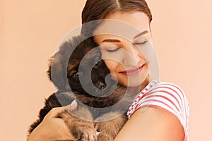 Portrait of German shepherd puppy posing on woman`s hands