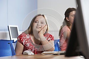 Portrait of girl (10-12) with Down syndrome in computer lab