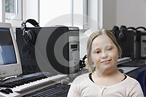 Portrait of girl (10-12) with Down syndrome in home recording studio