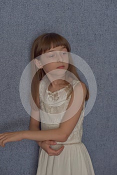 Portrait. Girl 9 years old on a background of blue wallpaper at home