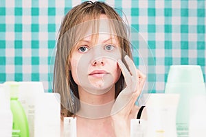 Portrait of girl applying the cosmetic product in bathroom