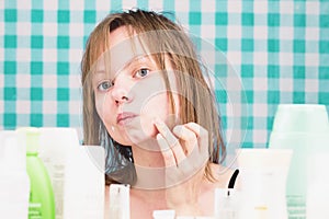 Portrait of girl applying the cosmetic product in bathroom