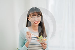 Portrait of a girl with bawl of salad looking at camera