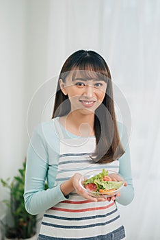 Portrait of a girl with bawl of salad looking at camera