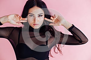 Portrait of a girl in a black dress on a pink background