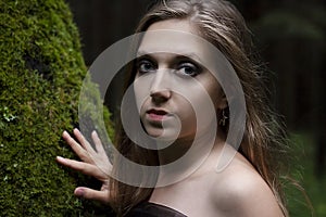 Portrait of a girl with black make-up in the forest