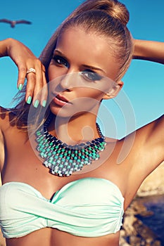 Portrait of girl with blond hair and bright makeup in bikini