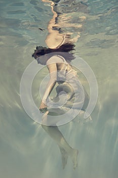 Portrait of a girl in a blue dress floating underwater