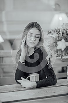 Portrait of a girl. Brunette in a coffee shop. elegant lady in a black dress, in a restaurant alone. Girl in a cafe